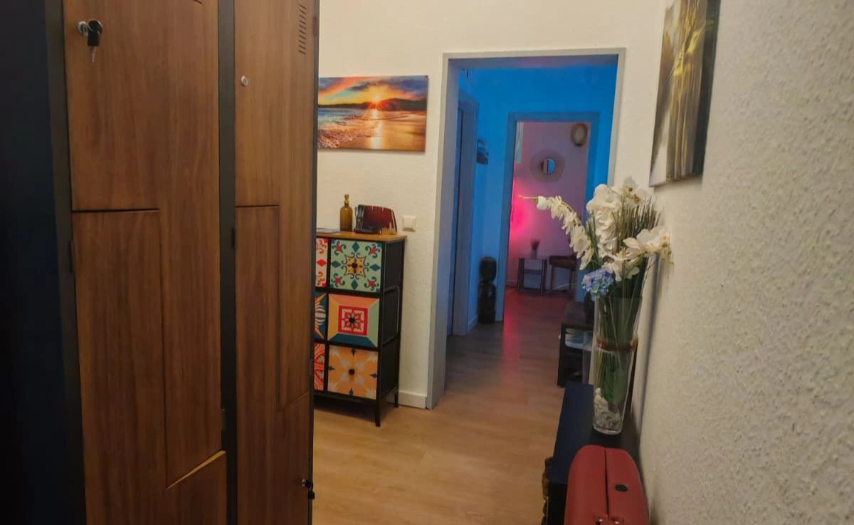 Flur Men2Men Schöneberg mit Schließfächern, Blumendekoration und Blick in den Massageraum